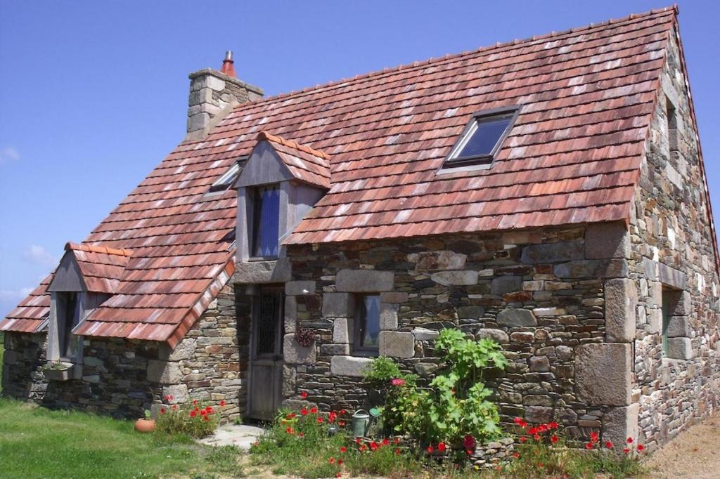 une ancienne maison en pierre avec un toit rouge dans l'établissement Stone House near Rosa Granite Coast, à Bas Kerhain