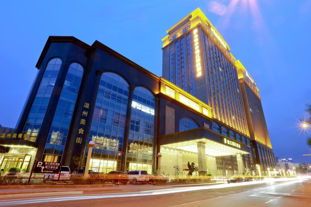 a large building with lights on in front of a street at JinJiang International Hotel Urumqi in Ürümqi
