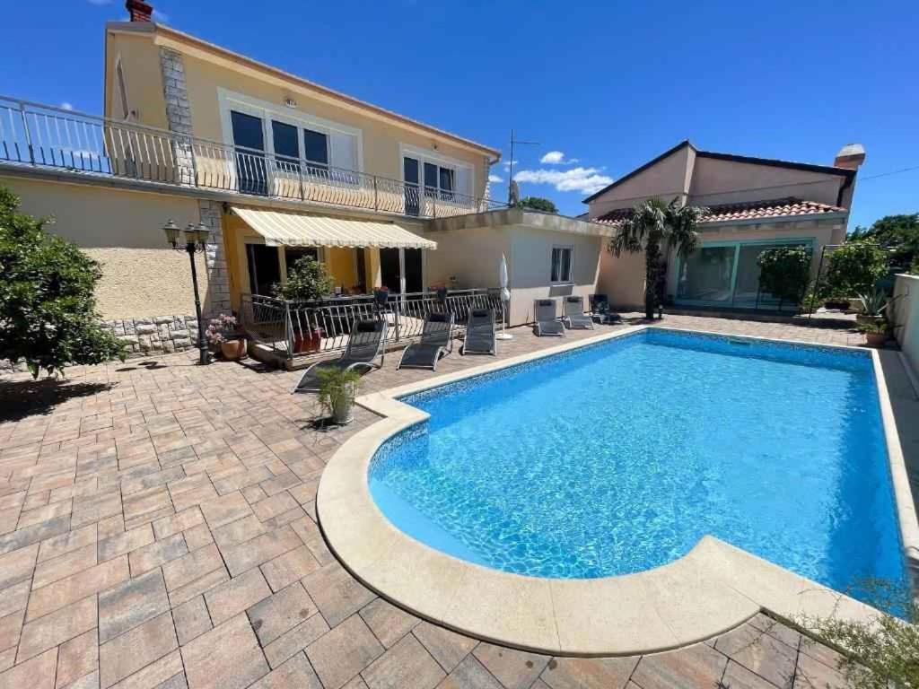 a swimming pool in front of a house at Holiday home in Jadranovo 42254 in Jadranovo