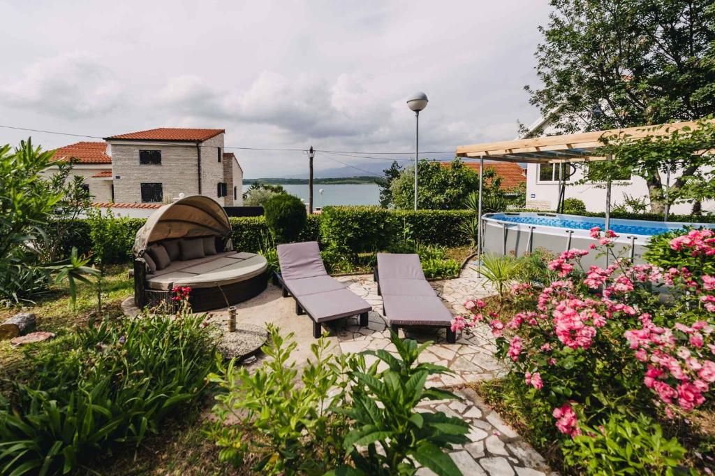 a patio with two chairs and a bench and flowers at Apartments in Klimno - Insel Krk 42235 in Klimno
