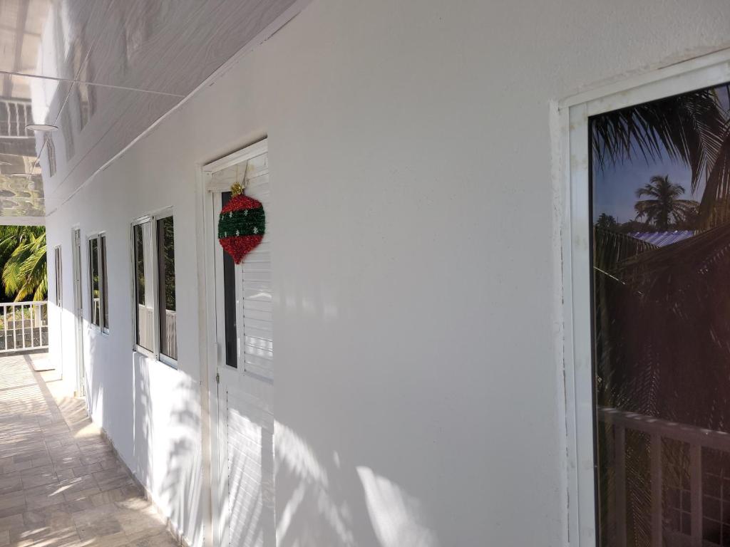 uma coroa de Natal pendurada ao lado de uma casa branca em posada kyca cerca ala playa em Buenavista