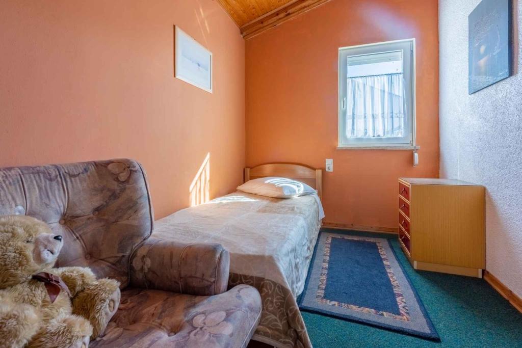 um urso de peluche sentado numa cadeira num quarto em Apartment in Crikvenica 42252 em Crikvenica