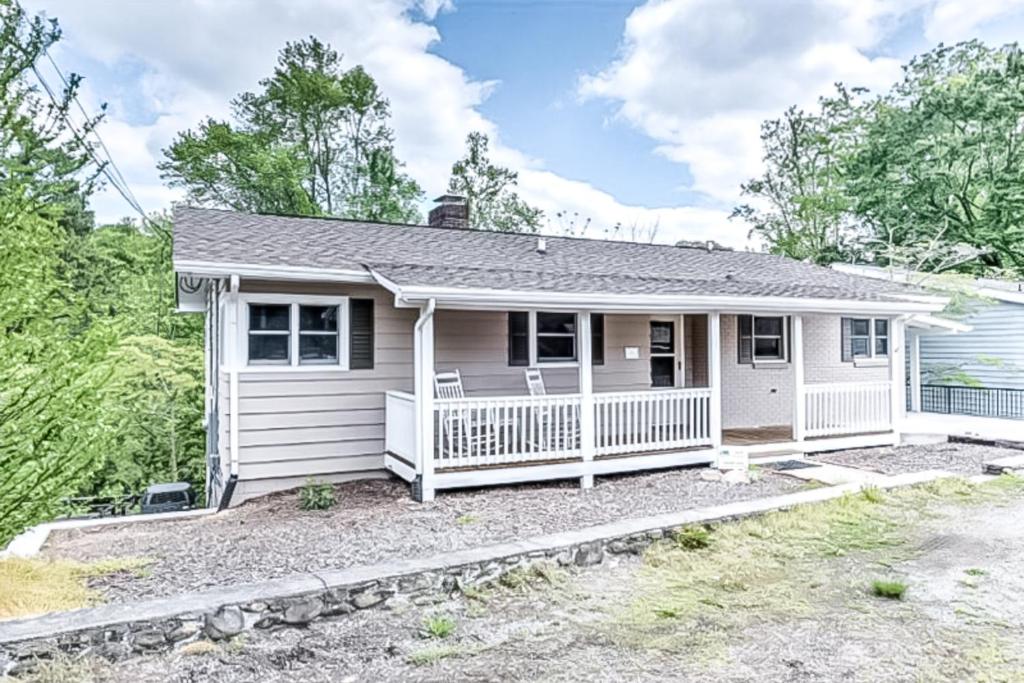 a small white house with a porch at Oxford Lodge in Lake Junaluska