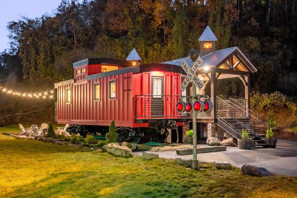 a small red train car sitting in a yard at Smoky Mountain Station in Pigeon Forge