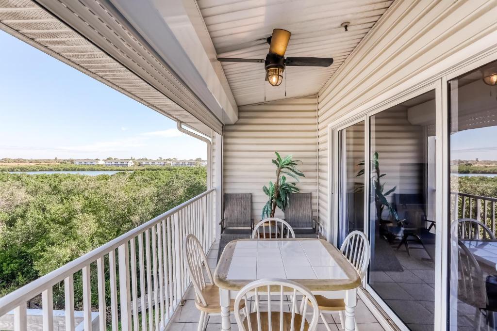 a porch with a table and chairs and a ceiling fan at Gulf Getaway in Clearwater Beach