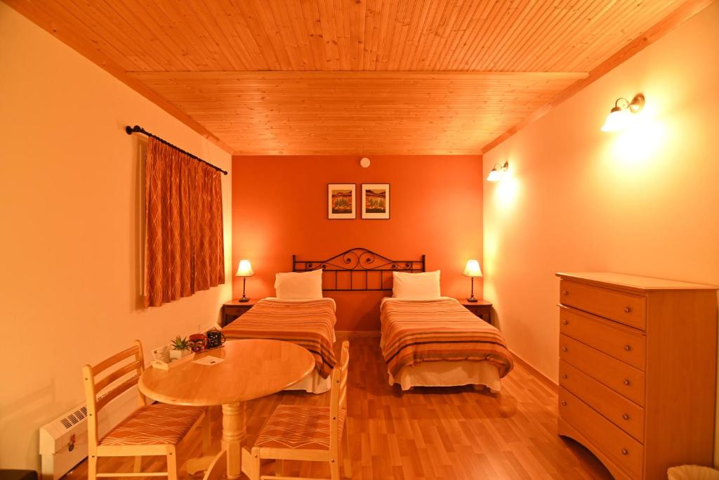 a bedroom with two beds and a table in it at Kaleido Lodge Yukon in Whitehorse