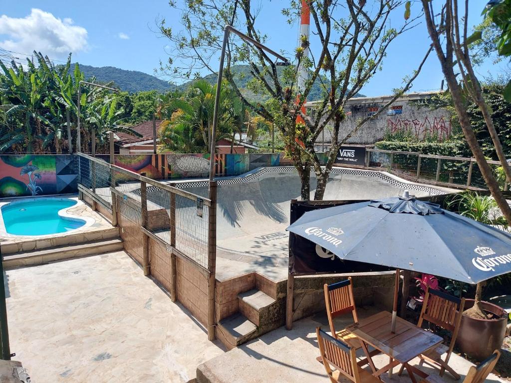 a patio with an umbrella and a swimming pool at Tree Park Cambury in Camburi