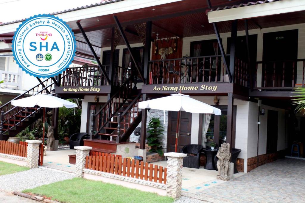 a restaurant with two umbrellas in front of a building at Ao Nang Home Stay - Adults Only in Ao Nang Beach