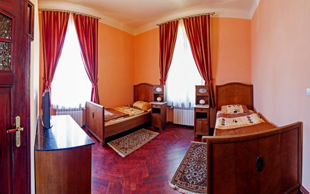 a room with two beds and two windows at Villa Bergera in Dzierżoniów
