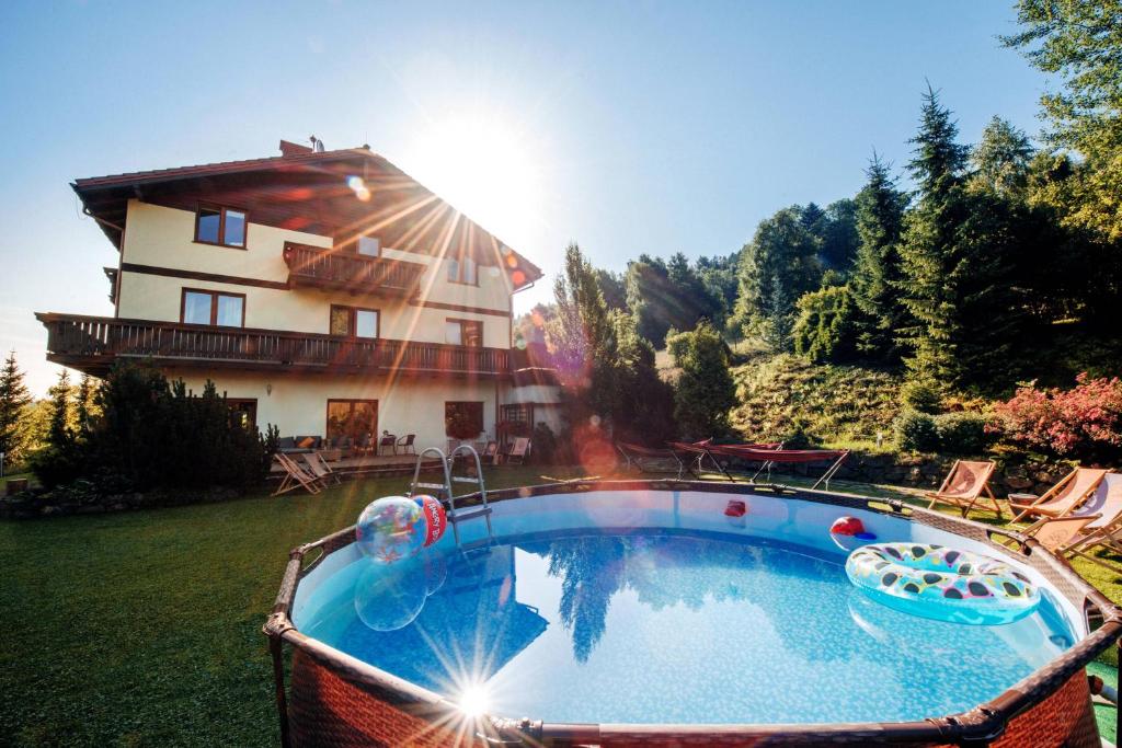 a large swimming pool in front of a house at Przystanek Góry in Szczyrk