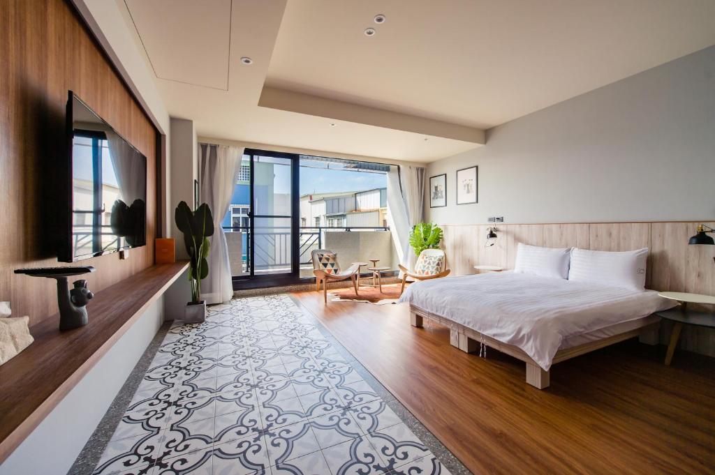 台南的住宿－蛙滴家，一间带大床的卧室和一个阳台