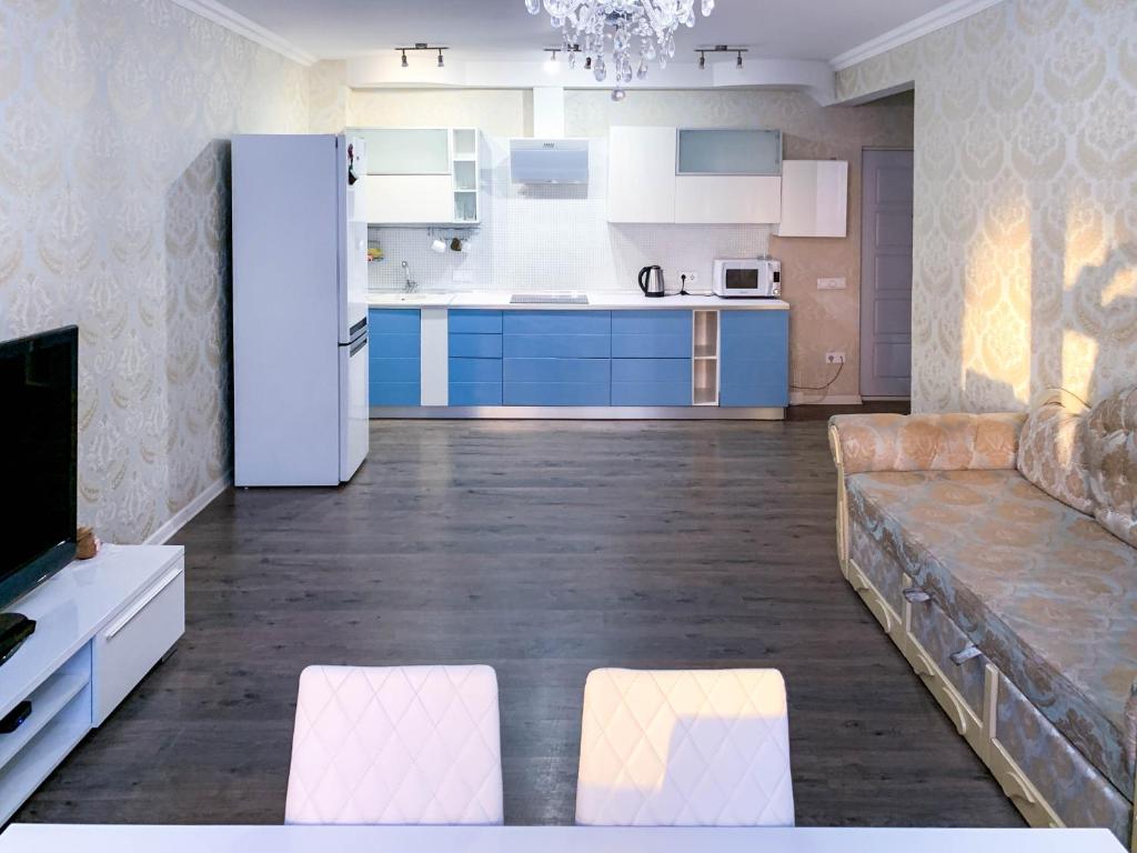 een keuken met blauwe kasten en een witte koelkast bij 2к квартира на Академгородке in Kiev