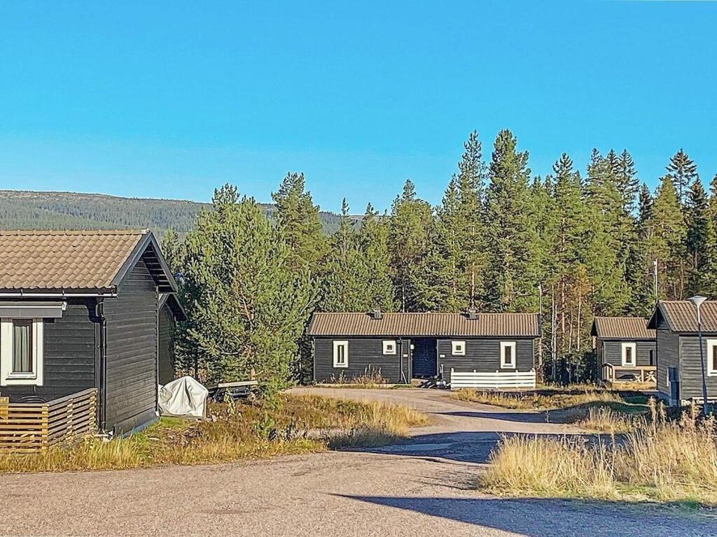 uma fila de casas em frente a uma floresta em 4 person holiday home in S LEN em Stöten