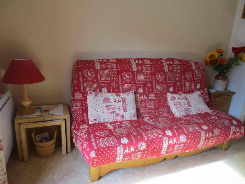 un sofá rojo en una habitación con una mesa y una lámpara en Studio Valloire, 1 pièce, 4 personnes - FR-1-263-69, en Valloire