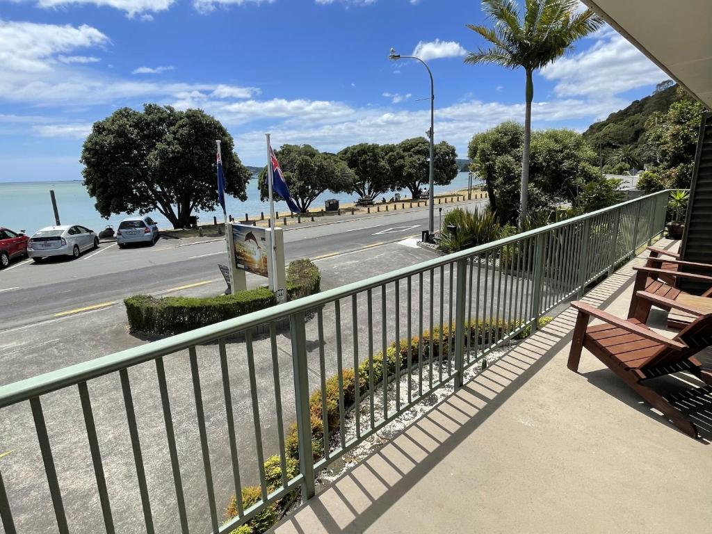 uma varanda com vista para uma rua e uma estrada em Bay Sands Seafront Studios em Paihia