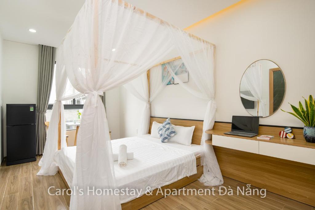 a bedroom with a white canopy bed with a mirror at Carol Homestay & Apartment Da Nang 3 in Da Nang