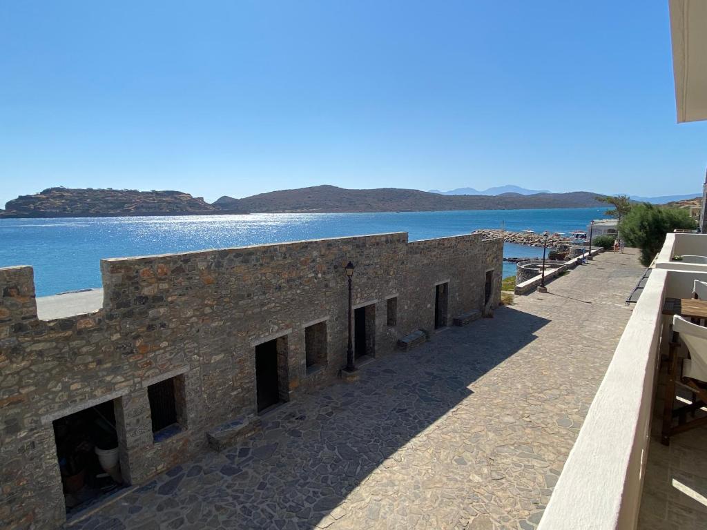 a brick building next to a body of water at Plaka Bleu Apartments in Pláka