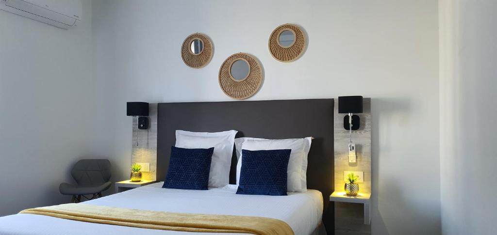 1 dormitorio con 1 cama grande con almohadas y espejos azules en Hôtel L'Alsace-Gare sncf, en Narbona