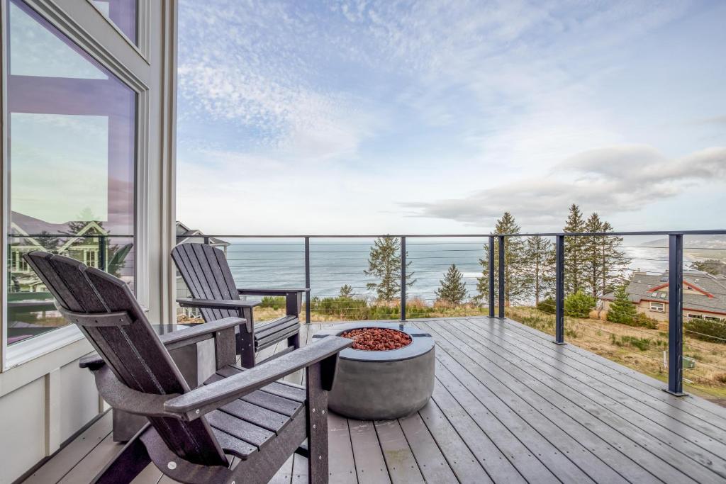 zwei Stühle auf einer Terrasse mit Blick auf das Meer in der Unterkunft Neskowin South Beach Home - Meredith Lodging in Neskowin