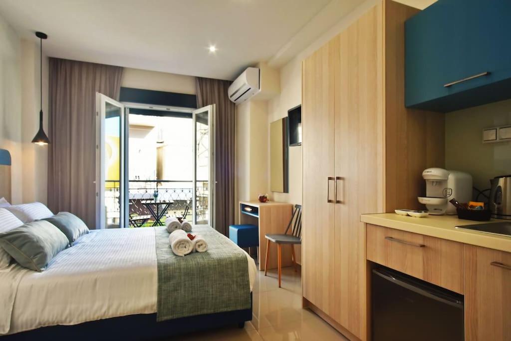 een slaapkamer met een bed en een keuken met een wastafel bij City Pearl Dntwn Apts in Heraklion