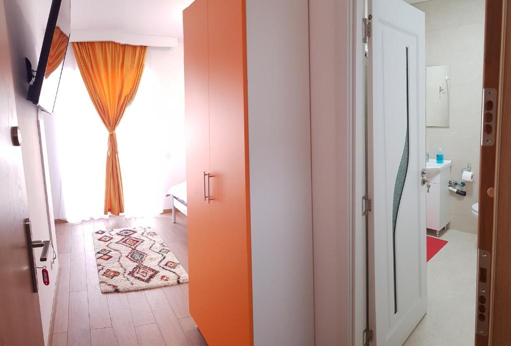 Una puerta abierta a un baño con una cortina naranja. en Apartament 6 Budiu, en Târgu Mureș