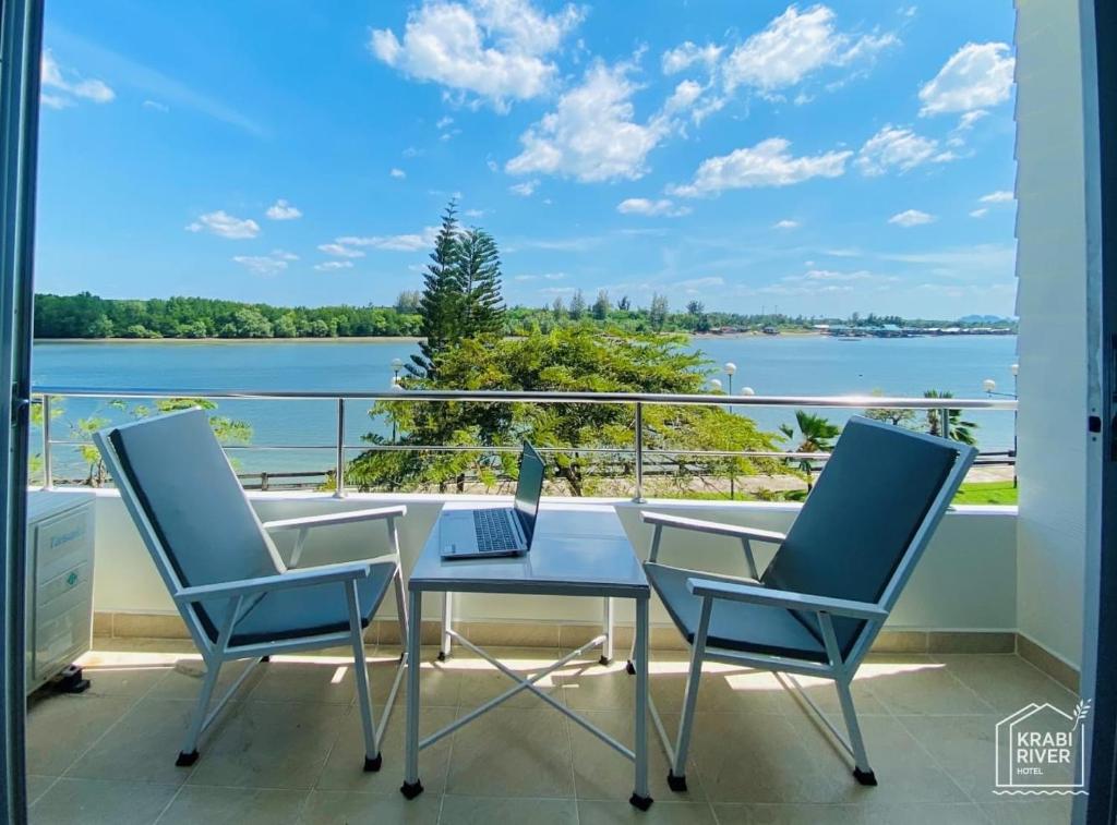 un balcone con tavolo, 2 sedie e computer portatile di Krabi River Hotel a Krabi town