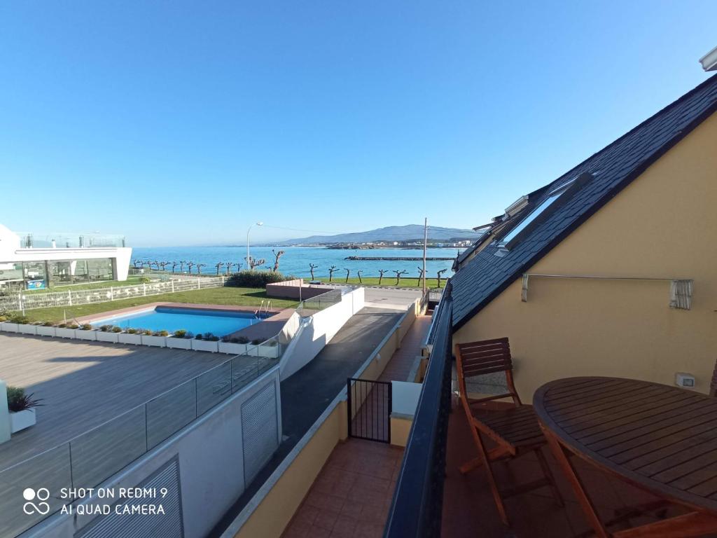 balcón con mesa y vistas al océano en Ático con dos terrazas, en Foz