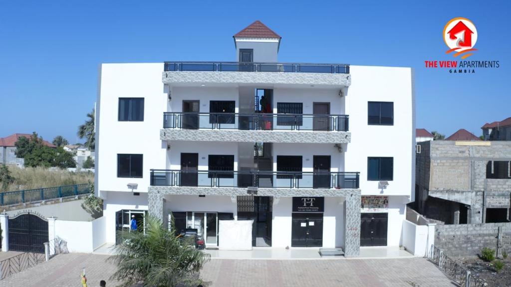 a white building with a balcony on top of it at The View Apartments in Brusubi