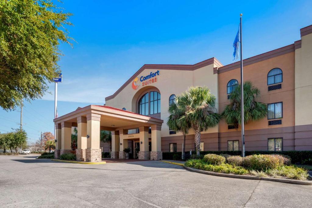 a front view of a hotel with palm trees at Comfort Suites Mobile East Bay in Daphne