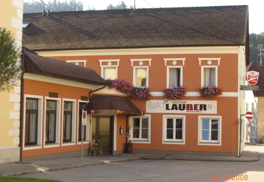a large orange building with flowers in the window at Gasthof Lauber in Offenhausen