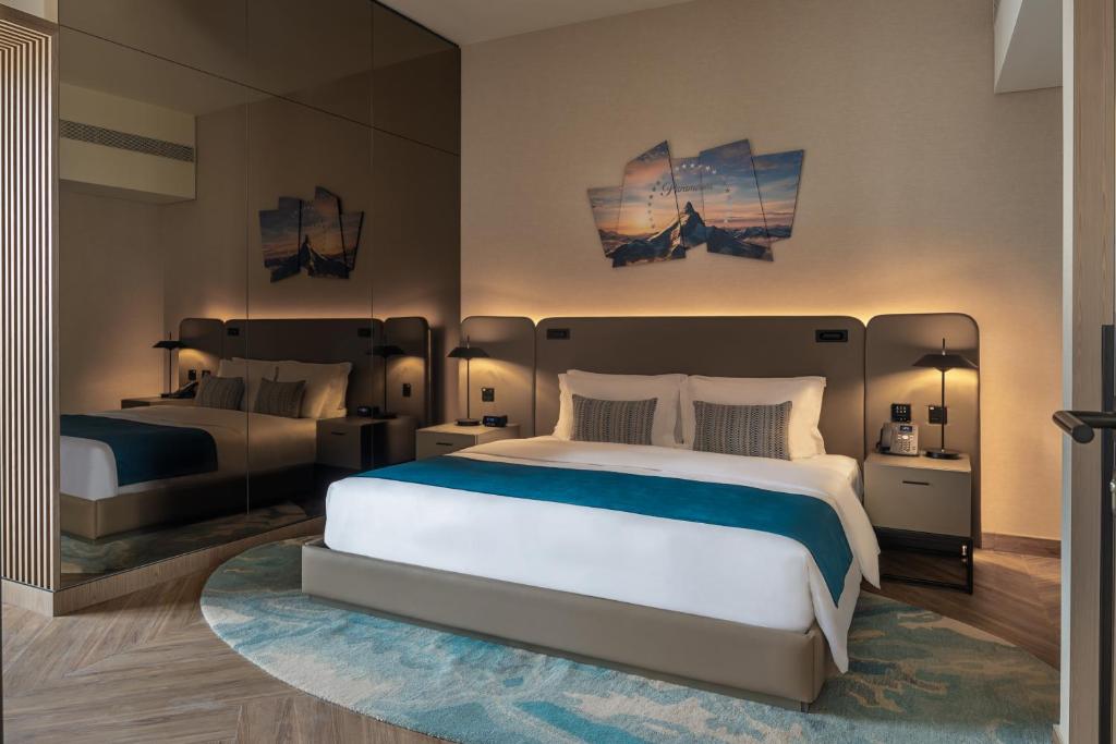 a bedroom with two beds and a large white bed at Paramount Hotel Midtown in Dubai