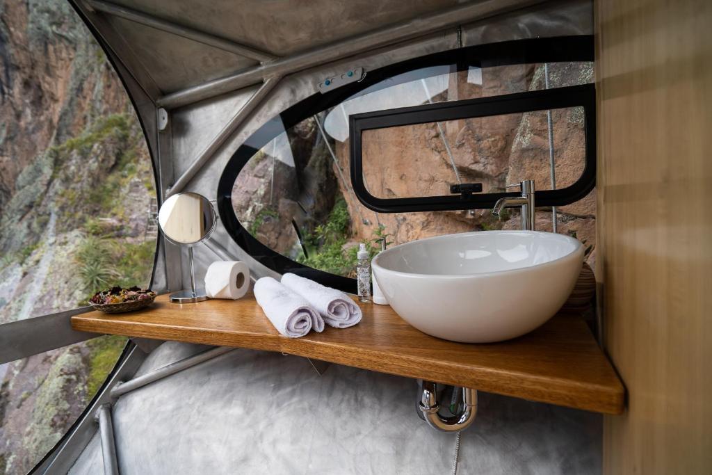 a bathroom with a sink and a mirror at Starlodge Adventure Suites in Urubamba