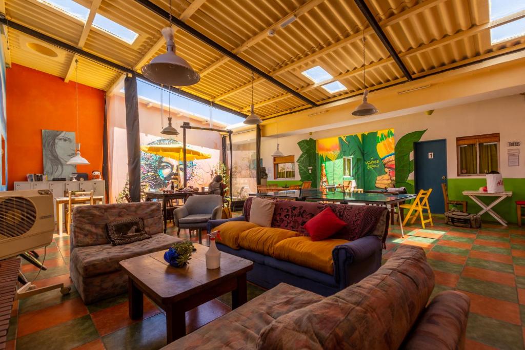 a living room with couches and a pool table at Del Barcito Hostel and Suites in Punta del Este