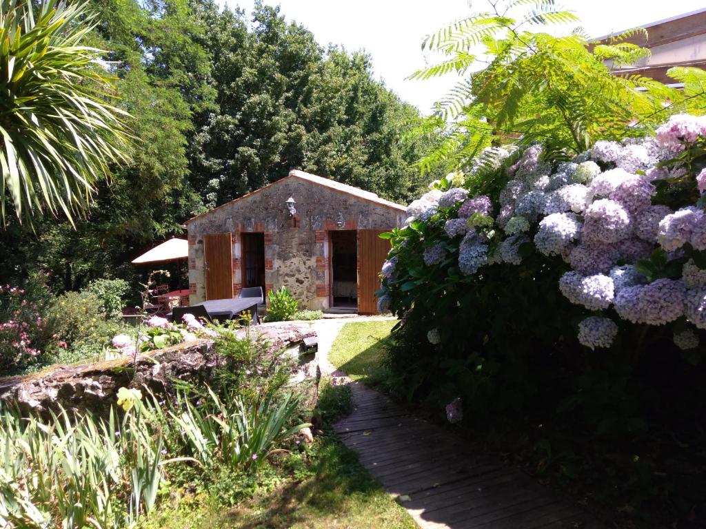 ogród z kamiennym domem i kwiatami w obiekcie Le POULAILLER w mieście Mareuil-sur-Lay