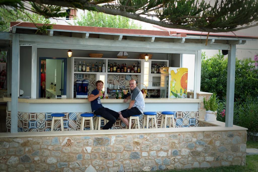 a man and a woman sitting at a bar at Kordistos Hotel in Kefalos