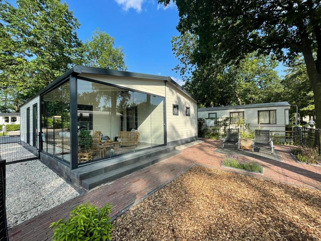 uma pequena casa com uma grande extensão de vidro em Casa 2234 op camping de Schatberg em Sevenum