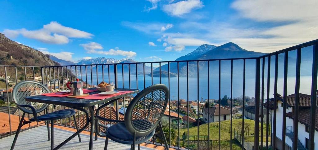 un tavolo e sedie su un balcone con vista sulle montagne di Appartamento Roberta a Musso