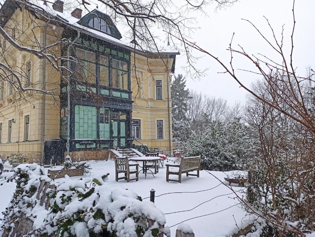 un edificio con una mesa y bancos en la nieve en Villa Petterhof, en Schottwien