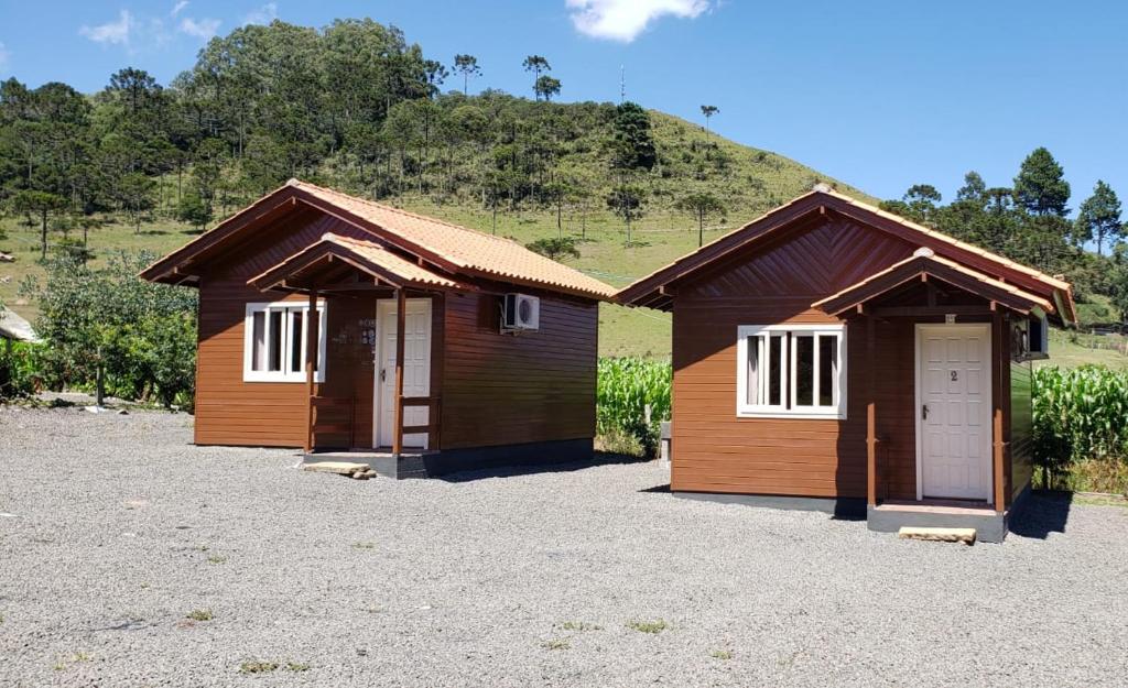 two small wooden buildings sitting in a parking lot at Amanhecer na Serra in Urubici