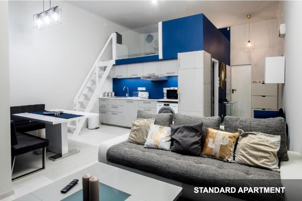 een woonkamer met een bank en een keuken bij Savouir Bleu Suite near Danube in Boedapest