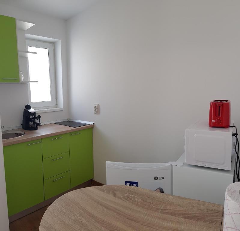 a kitchen with green cabinets and a red appliance at Apartament 7 Budiu in Târgu-Mureş