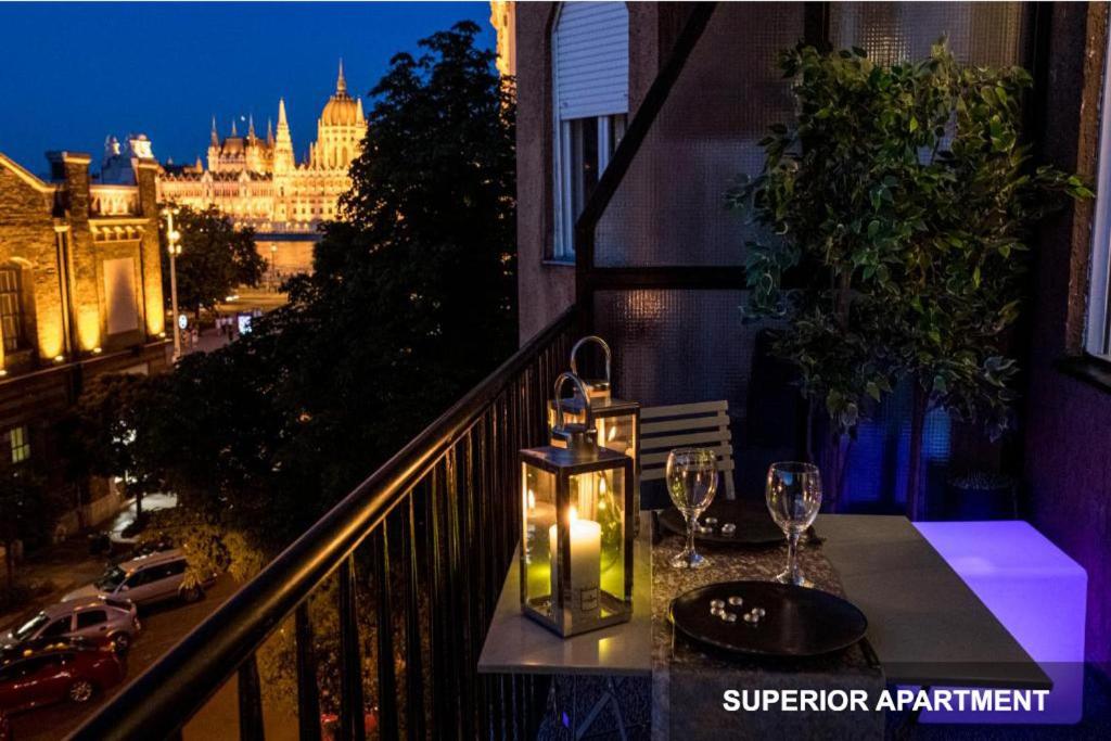 布達佩斯的住宿－BpR Agathé Elegant Suite with Parliament View，阳台上配有带酒杯和蜡烛的桌子