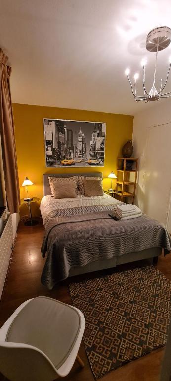 a bedroom with a large bed and a chair at Mi BnB Amsterdam in Amsterdam