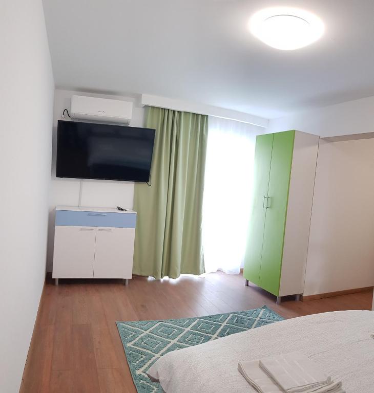 a living room with a tv and a bed and a room at Apartament 8 Budiu in Târgu-Mureş