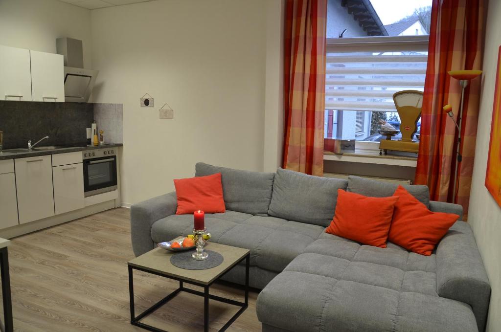 馬爾斯貝格的住宿－FEWO - ZurBank -，客厅配有灰色沙发和橙色枕头。