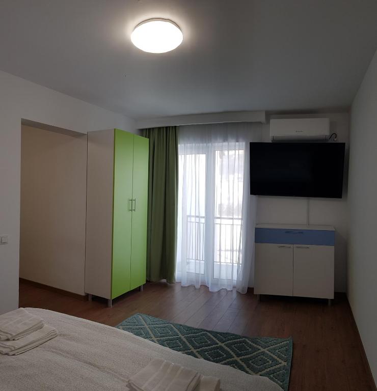 a bedroom with a bed and a flat screen tv at Apartament 10 Budiu in Târgu-Mureş
