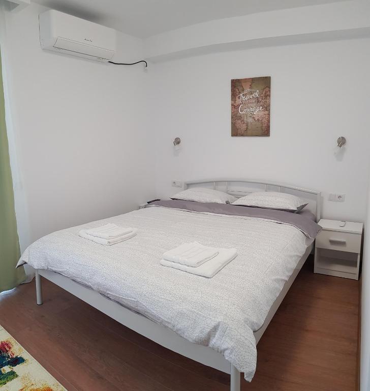 a white bed with two towels on top of it at Apartament 11 Budiu in Târgu-Mureş