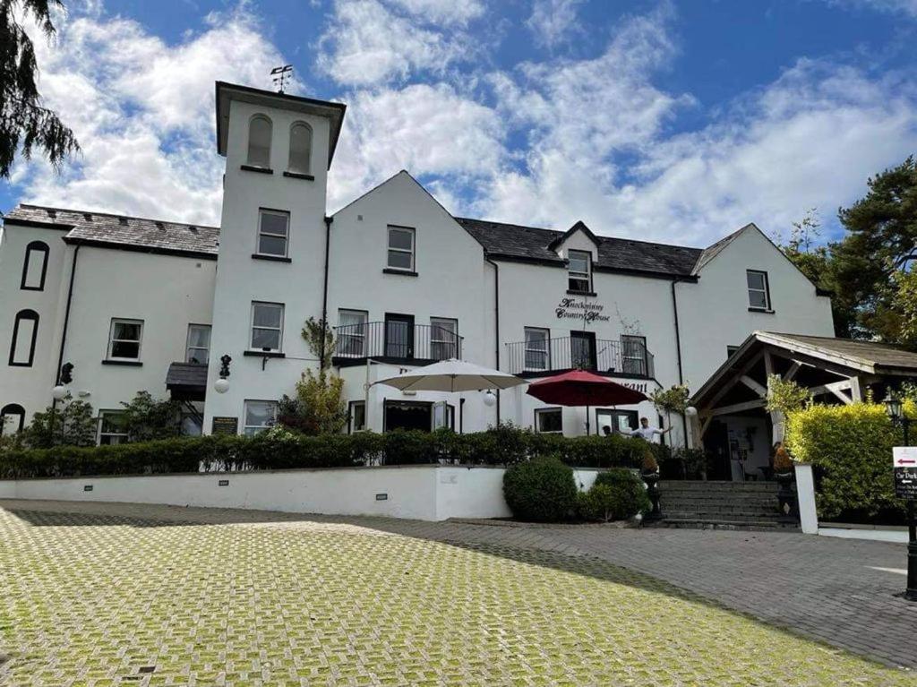 un gran edificio blanco con una torre de reloj en Knockninny Country House, en Derrylin