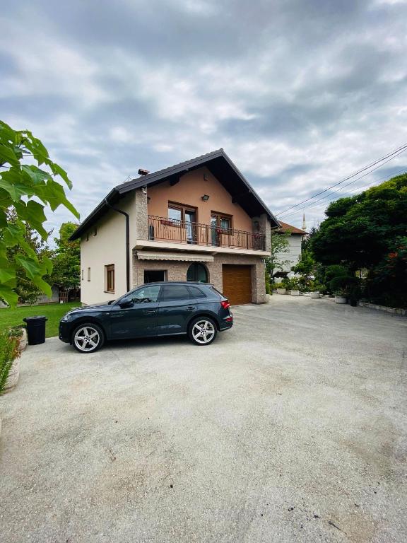 a black car parked in front of a house at Apartman Admir in Gladno Polje