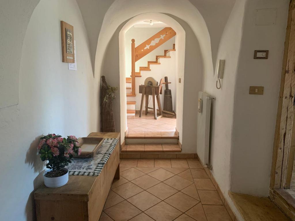 un couloir avec une table et des escaliers dans une maison dans l'établissement Maso Pallabazzer - Colle Santa Lucia, à Colle Santa Lucia